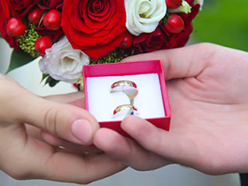 Обручальные кольца в руках жениха и невесты